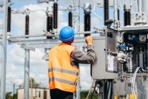 Técnico realizando mantenimiento en un transformador industrial, asegurando su correcto funcionamiento y eficiencia energética