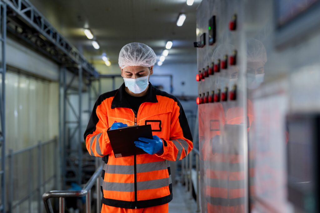 Técnico registrando protocolo de verificación junto a cuadro eléctrico industrial durante puesta en servicio — VOLTIA
