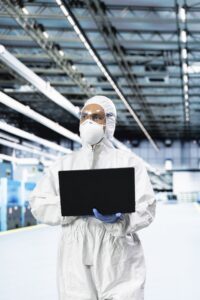 Técnico con EPI completo realizando verificaciones electrónicas en instalación industrial de alta tecnología — VOLTIA